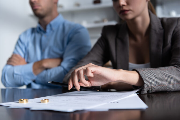 partial view of couple at table with divorce documents